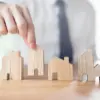 Man picking up wooden house
