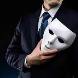 A businessman holding a mask